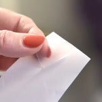 Hand peeling Mouth Tape off backing